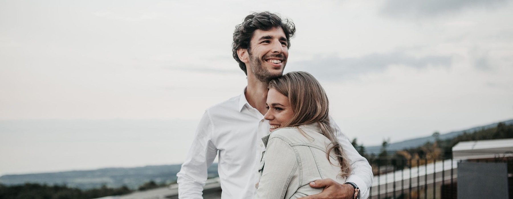 a man and woman hugging on rooftop terrace